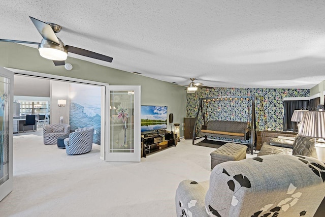 living area with carpet floors, a textured ceiling, lofted ceiling, and ceiling fan