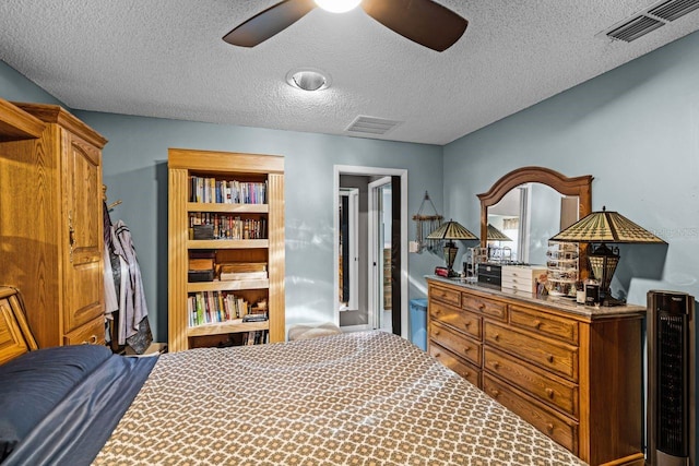 bedroom with a ceiling fan, beverage cooler, visible vents, and a textured ceiling