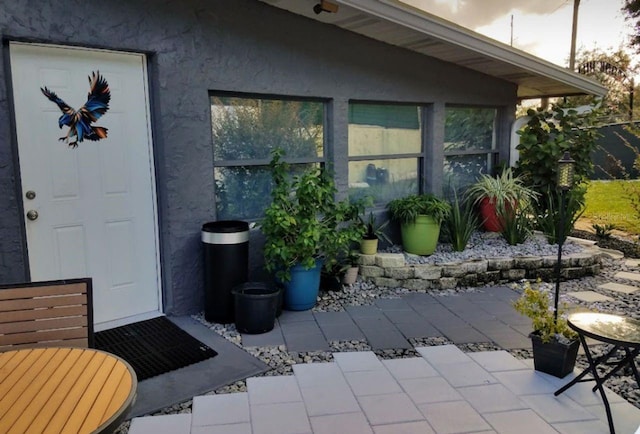 entrance to property featuring a patio and stucco siding