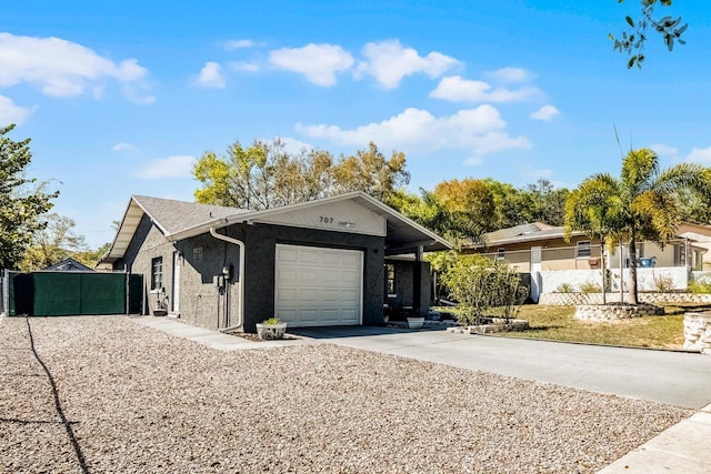 view of front of property featuring concrete driveway, an attached garage, and fence