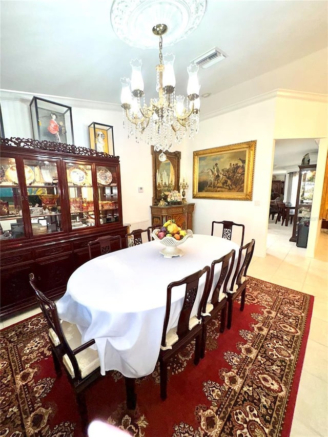 dining room featuring a notable chandelier, visible vents, crown molding, and light tile patterned flooring