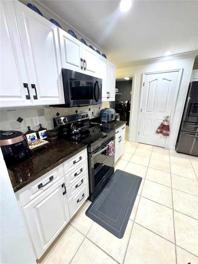 kitchen featuring refrigerator with ice dispenser, white cabinetry, dark stone counters, light tile patterned flooring, and range with two ovens