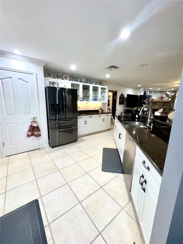 kitchen with visible vents, a sink, light tile patterned floors, glass insert cabinets, and black refrigerator with ice dispenser