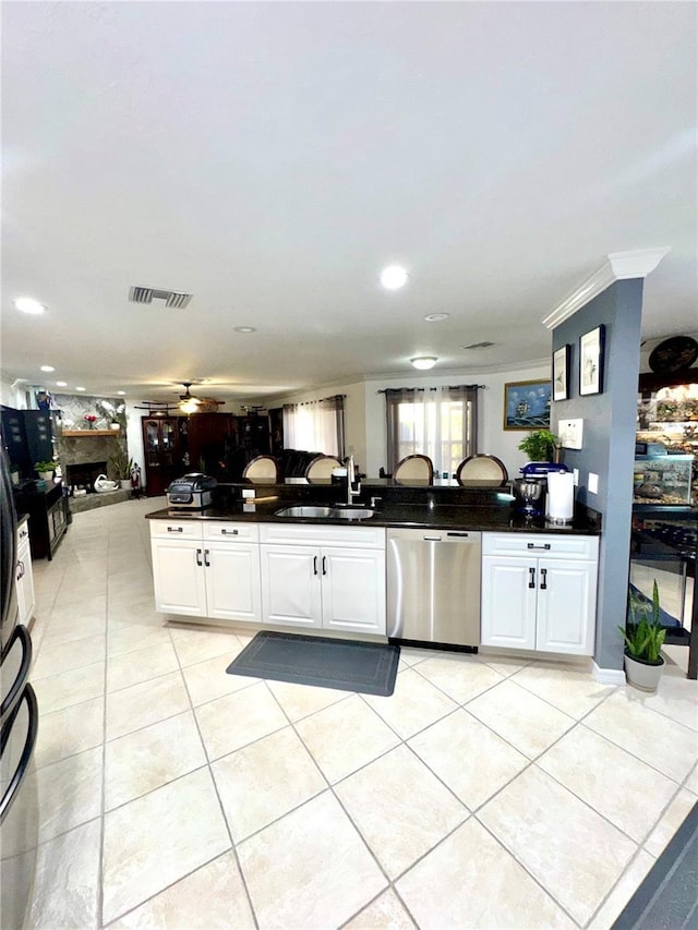 kitchen featuring dishwasher, dark countertops, light tile patterned floors, and a sink