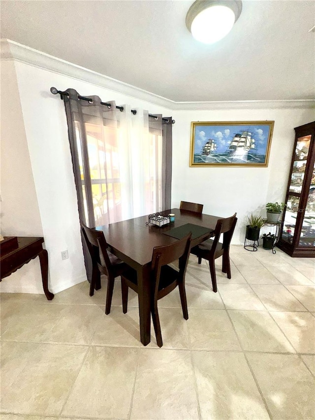 dining room with crown molding and light tile patterned floors