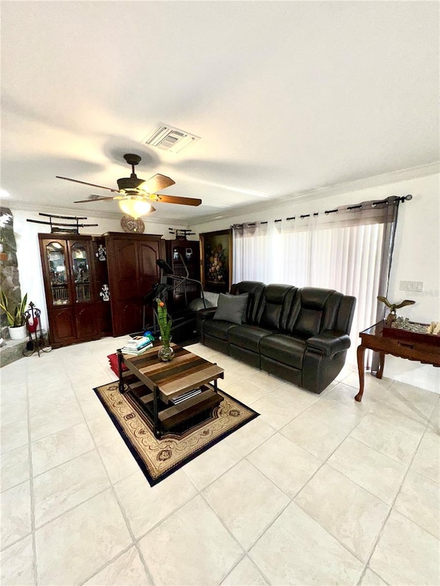 living area featuring crown molding, light tile patterned flooring, a ceiling fan, and visible vents