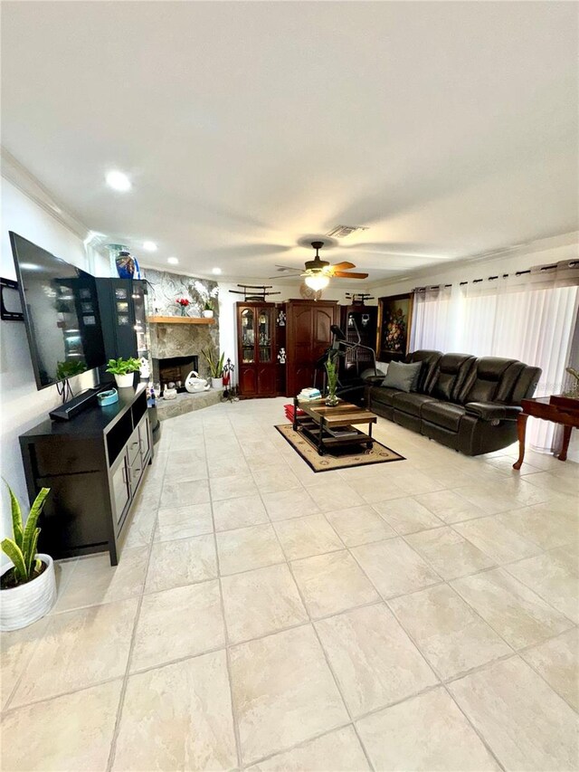 living room featuring a stone fireplace, recessed lighting, a ceiling fan, and visible vents