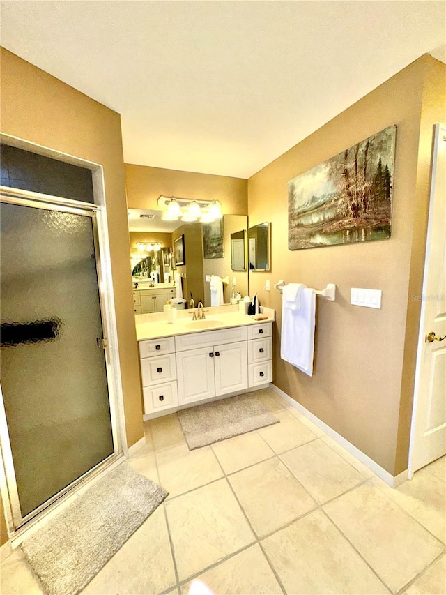 bathroom with tile patterned floors, a shower stall, vanity, and baseboards