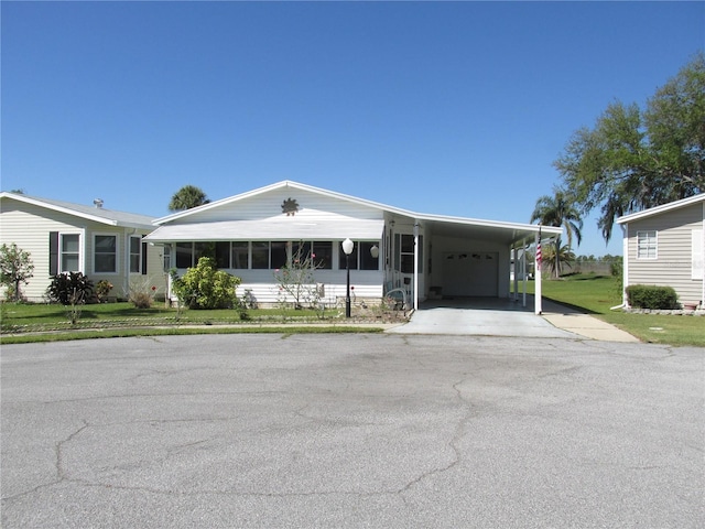 view of front of property featuring a front yard, a carport, and driveway