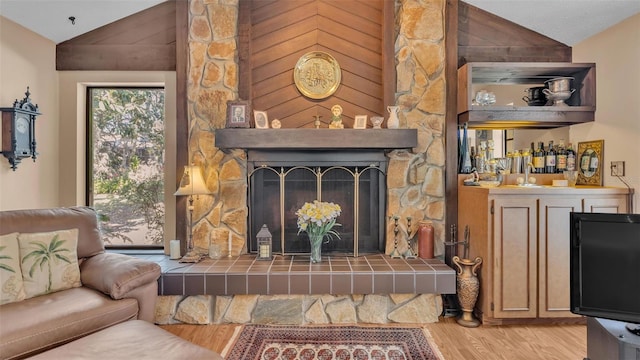 living room with vaulted ceiling, wood finished floors, and a fireplace