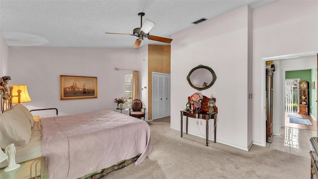 bedroom featuring a ceiling fan, baseboards, visible vents, a textured ceiling, and light carpet