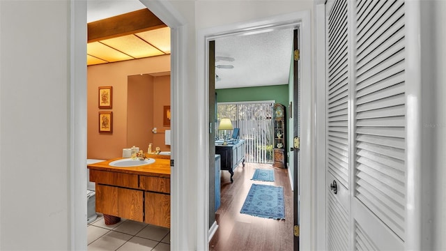 interior space featuring a textured ceiling, light tile patterned floors, and a sink