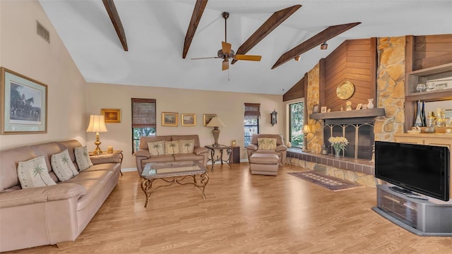 living area featuring visible vents, wood finished floors, beamed ceiling, and ceiling fan