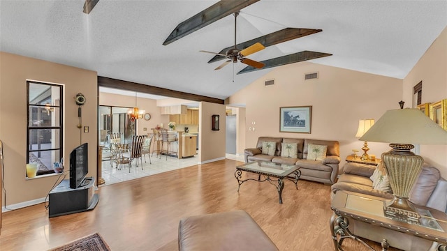 living room featuring light wood-type flooring, visible vents, a textured ceiling, and ceiling fan