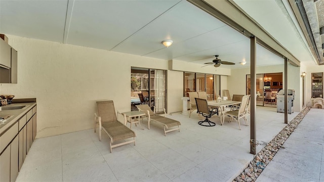 view of patio featuring ceiling fan, outdoor dining space, and a sink