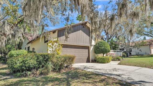 view of front of house featuring driveway, an attached garage, and a front lawn