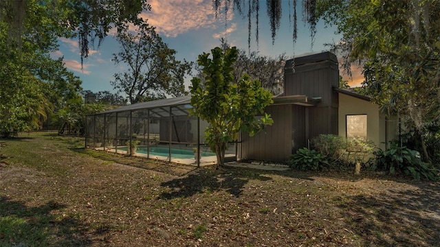 view of yard featuring an outdoor pool and glass enclosure