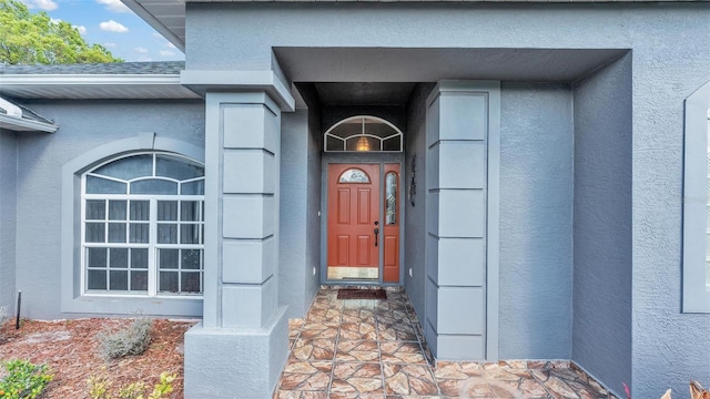 entrance to property with stucco siding