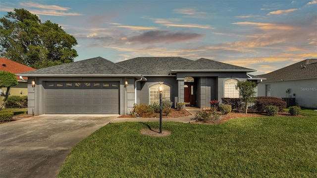 ranch-style house featuring cooling unit, driveway, a yard, stucco siding, and a garage