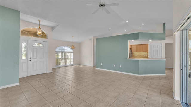 unfurnished living room with baseboards, lofted ceiling, light tile patterned flooring, recessed lighting, and ceiling fan with notable chandelier