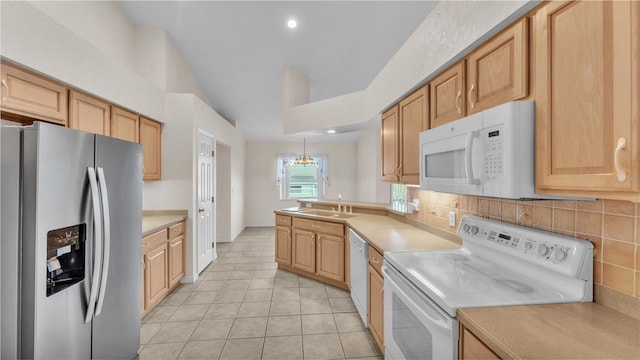 kitchen with a sink, tasteful backsplash, white appliances, light countertops, and light tile patterned floors