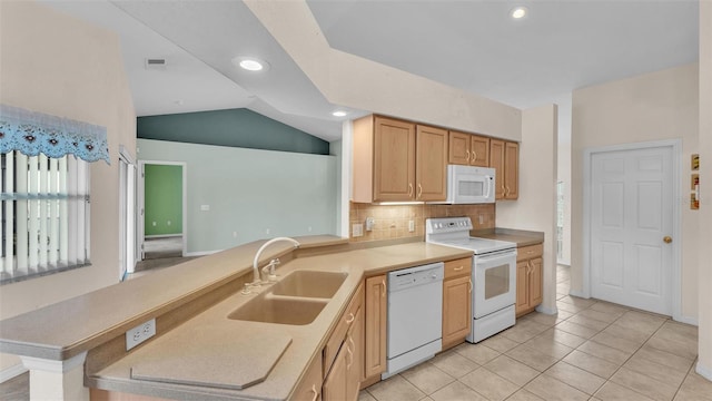 kitchen with tasteful backsplash, vaulted ceiling, a peninsula, white appliances, and a sink