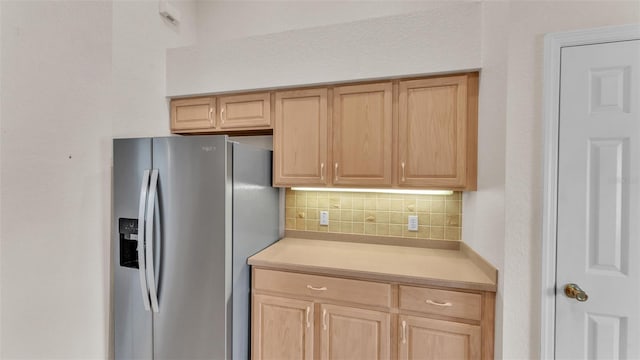 kitchen with decorative backsplash, light countertops, stainless steel fridge with ice dispenser, and light brown cabinets