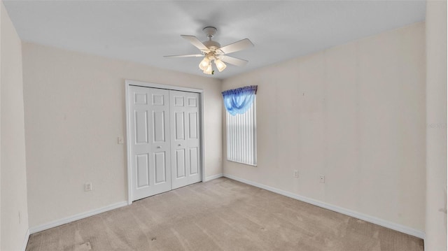 unfurnished bedroom featuring a closet, baseboards, carpet, and a ceiling fan