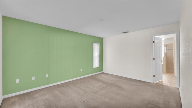 carpeted empty room with visible vents and baseboards