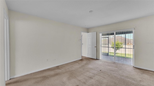 carpeted empty room with baseboards