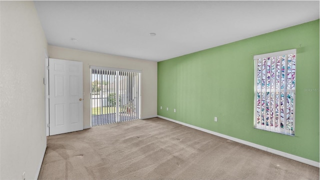 carpeted empty room featuring baseboards