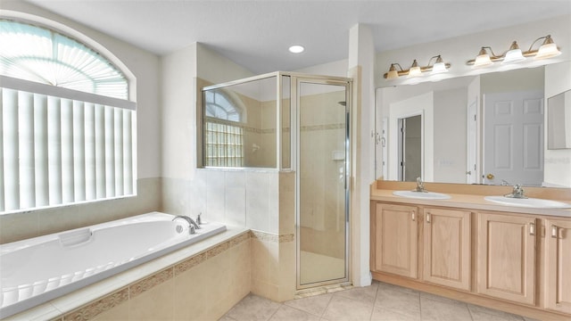 full bath with tile patterned floors, a shower stall, and a sink