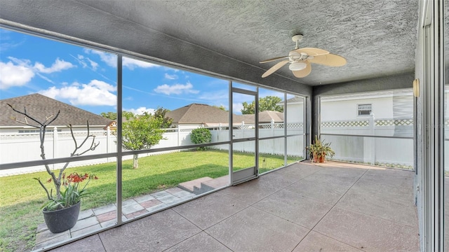 unfurnished sunroom with a ceiling fan