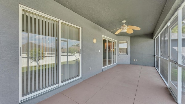 unfurnished sunroom with ceiling fan