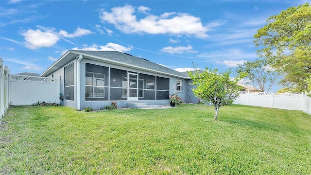 rear view of property with a sunroom, a lawn, a fenced backyard, and stucco siding