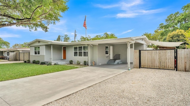 ranch-style home with a gate, fence, concrete driveway, a front yard, and a carport