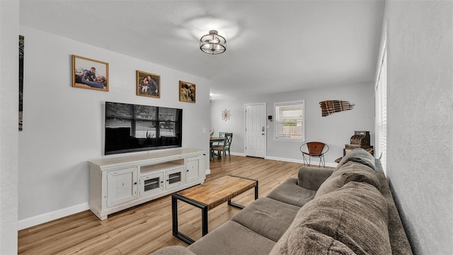 living room featuring baseboards and light wood-style flooring