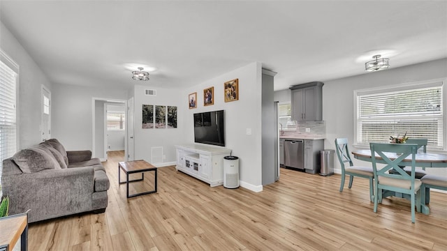 living area with visible vents, baseboards, and light wood-style floors