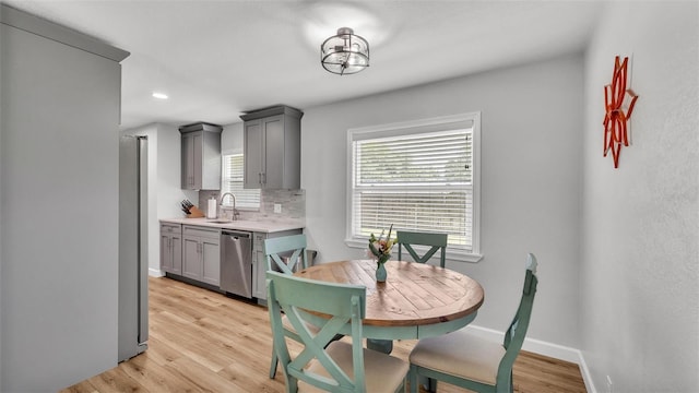 dining area with baseboards and light wood-style flooring