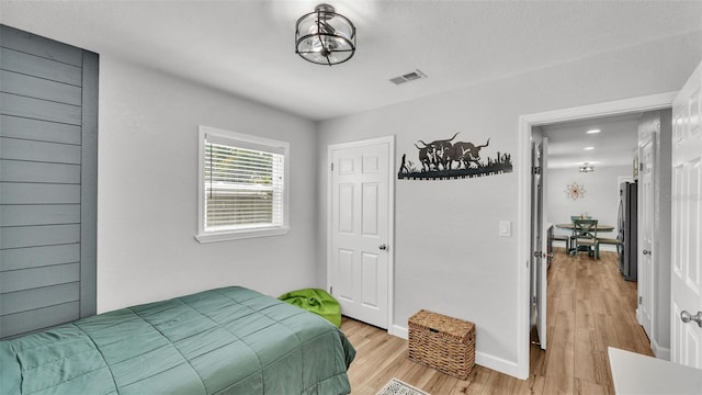 bedroom featuring visible vents, baseboards, and light wood-style flooring