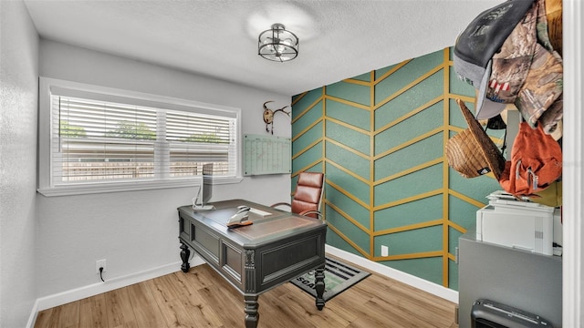 interior space featuring a textured ceiling, baseboards, and wood finished floors