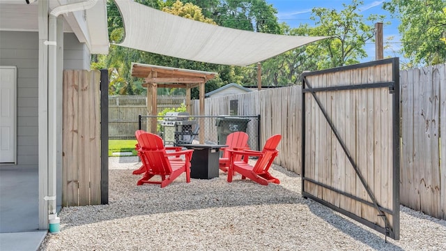 view of patio with area for grilling, fence, and an outdoor fire pit