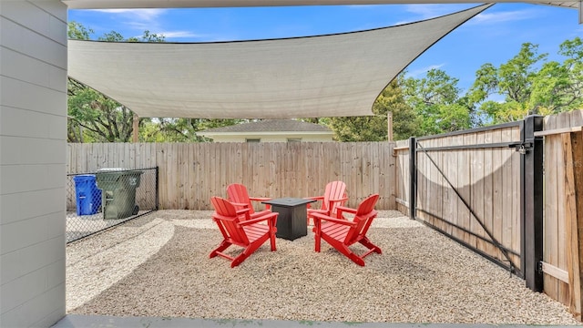 view of yard featuring a patio, a gate, a fenced backyard, and a fire pit