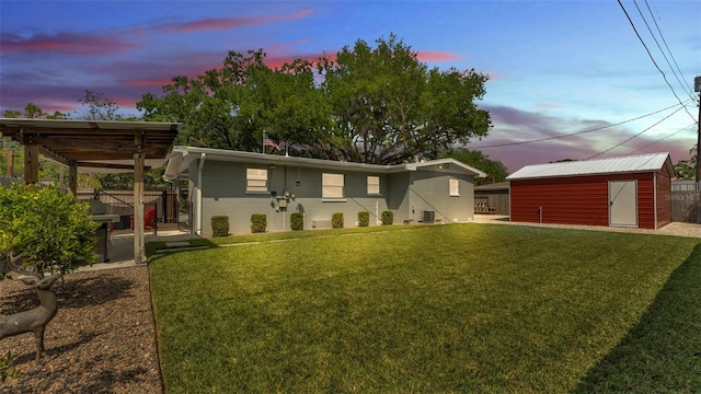 view of front of house featuring a front lawn, a patio area, fence, and an outdoor structure