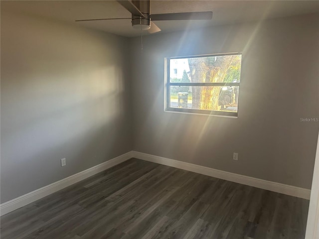 unfurnished room featuring a ceiling fan, baseboards, and dark wood-style flooring