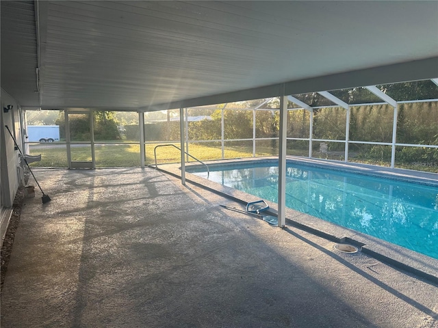 outdoor pool featuring glass enclosure and a patio