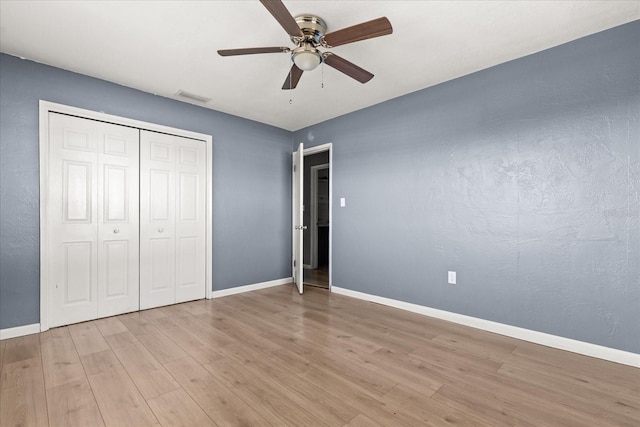 unfurnished bedroom featuring visible vents, baseboards, and wood finished floors