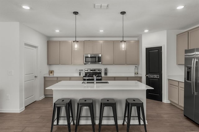 kitchen with a kitchen breakfast bar, wood finished floors, visible vents, and stainless steel appliances