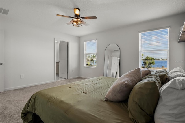 bedroom with ceiling fan, light colored carpet, visible vents, and baseboards