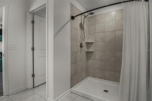 bathroom featuring tile patterned flooring, a shower stall, and baseboards